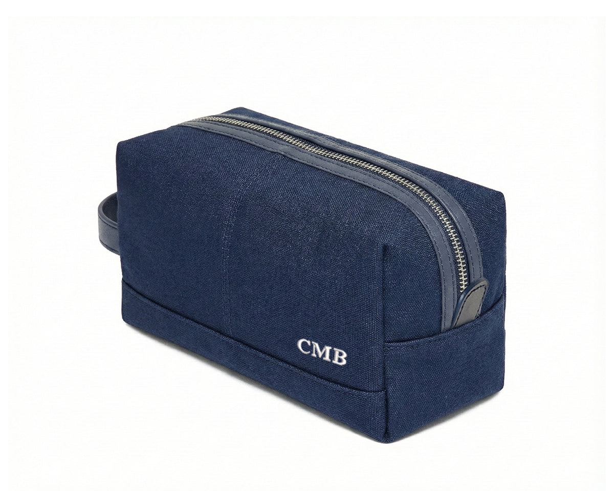 The Littler Dopp Kit: Navy Ballistic - White Embroidery, featuring a navy-blue canvas, top metal zipper, leather pull, side handle, and embroidered initials “CMB”.