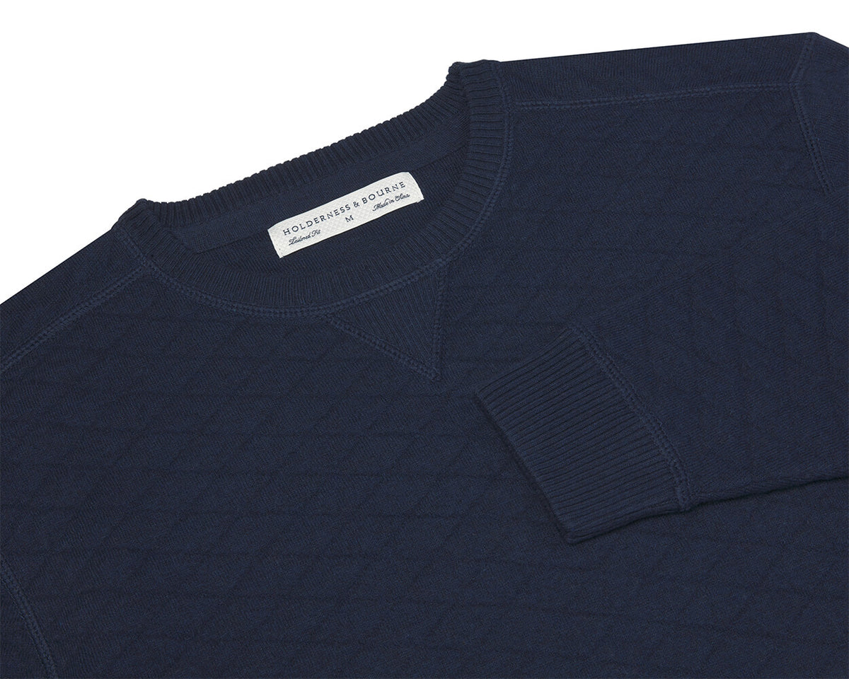 The Ward Crewneck Sweater: Heathered Navy, featuring a quilted-texture and diamond jacquard knit, showcases a woven label “HOLDERNESS & BOURNE,” size M.