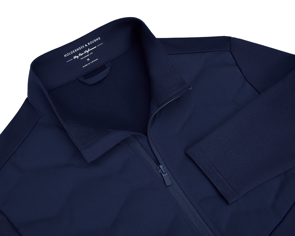 The Brodie Jacket: Navy, showcasing a full-zip design with insulated chest panels, technical stretch fabric, stand-up collar, and low-profile side zip pockets.