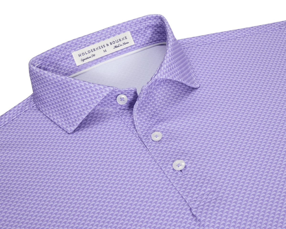 The Eaton Shirt: Tudor, a lavender-purple men’s polo with geometric texture, features a spread collar, three-button placket, and is designed for warm-weather performance.