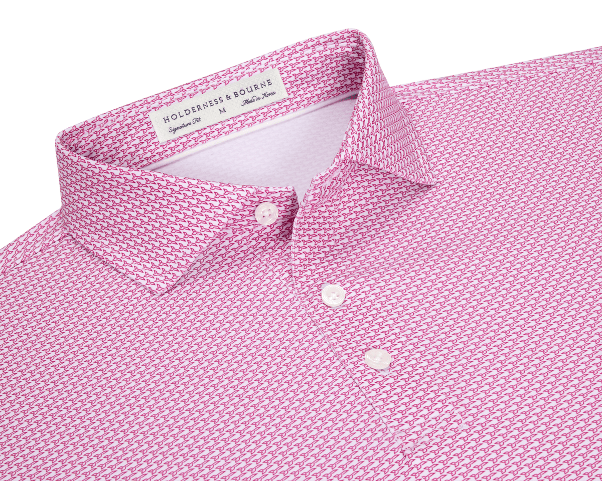 The Hanover Shirt: Cabernet, showing a close-up of the collar and placket with mother-of-pearl buttons, features a pink geometric jet pattern and label details.