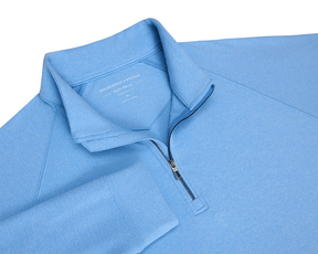 The Westland Quarter-Zip: Heathered Vista Blue features a light-blue, long-sleeve design with a stand-up collar, showcasing a sleek gunmetal chrome trim.