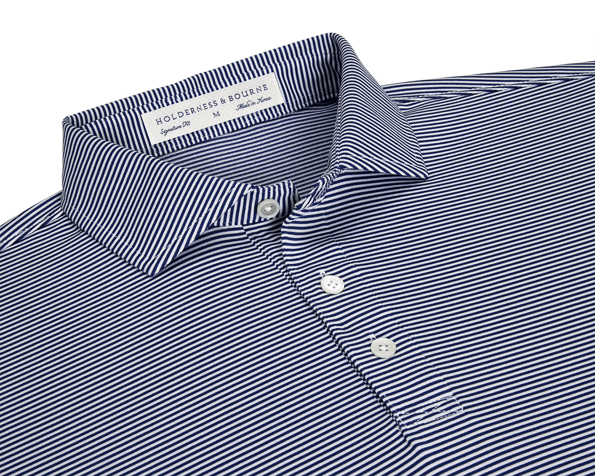 The Perkins Shirt: Navy & White features a micro-stripe knit with a point collar, three-button placket, and moisture-wicking performance fabric for versatile wear.