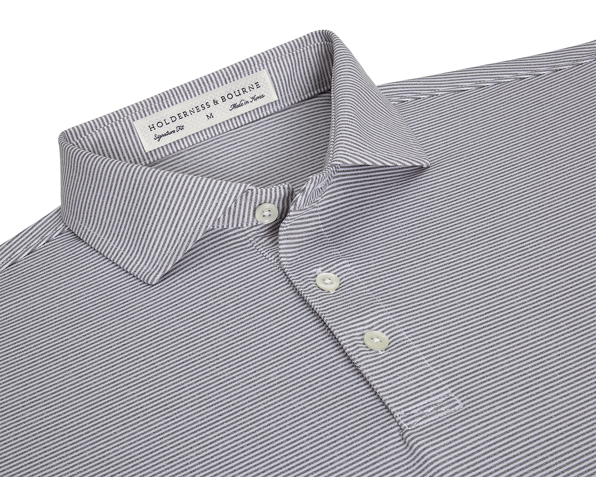 The Perkins Shirt: Gray & White, features a finely striped polo design with a structured collar, three-button placket, and performance fabric for comfort and protection.