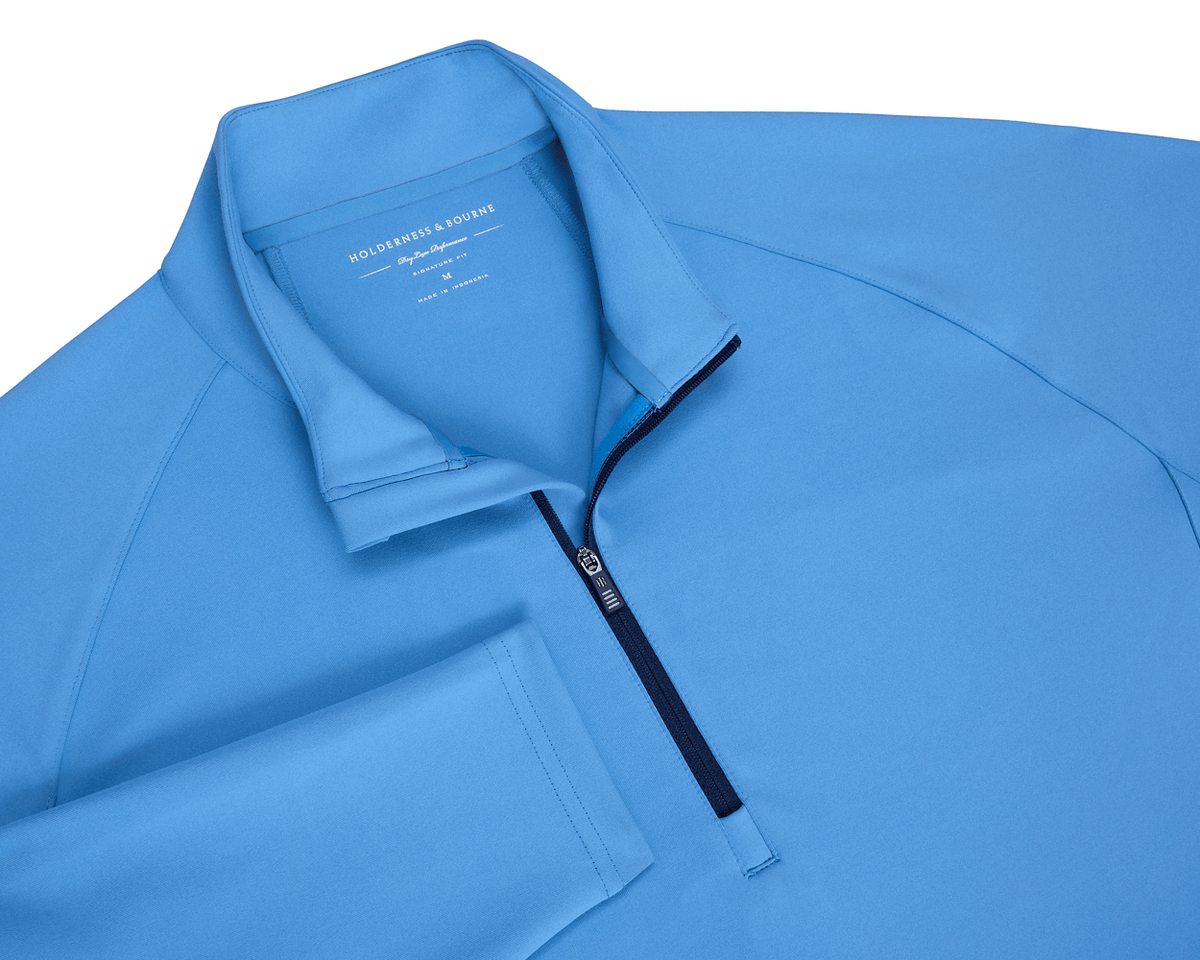 The Rodgers Quarter-Zip: Horizon Blue pullover with a mock-neck style and contrasting zipper, ideal for golf outings, offering stretch, warmth, and UPF 50+ protection.