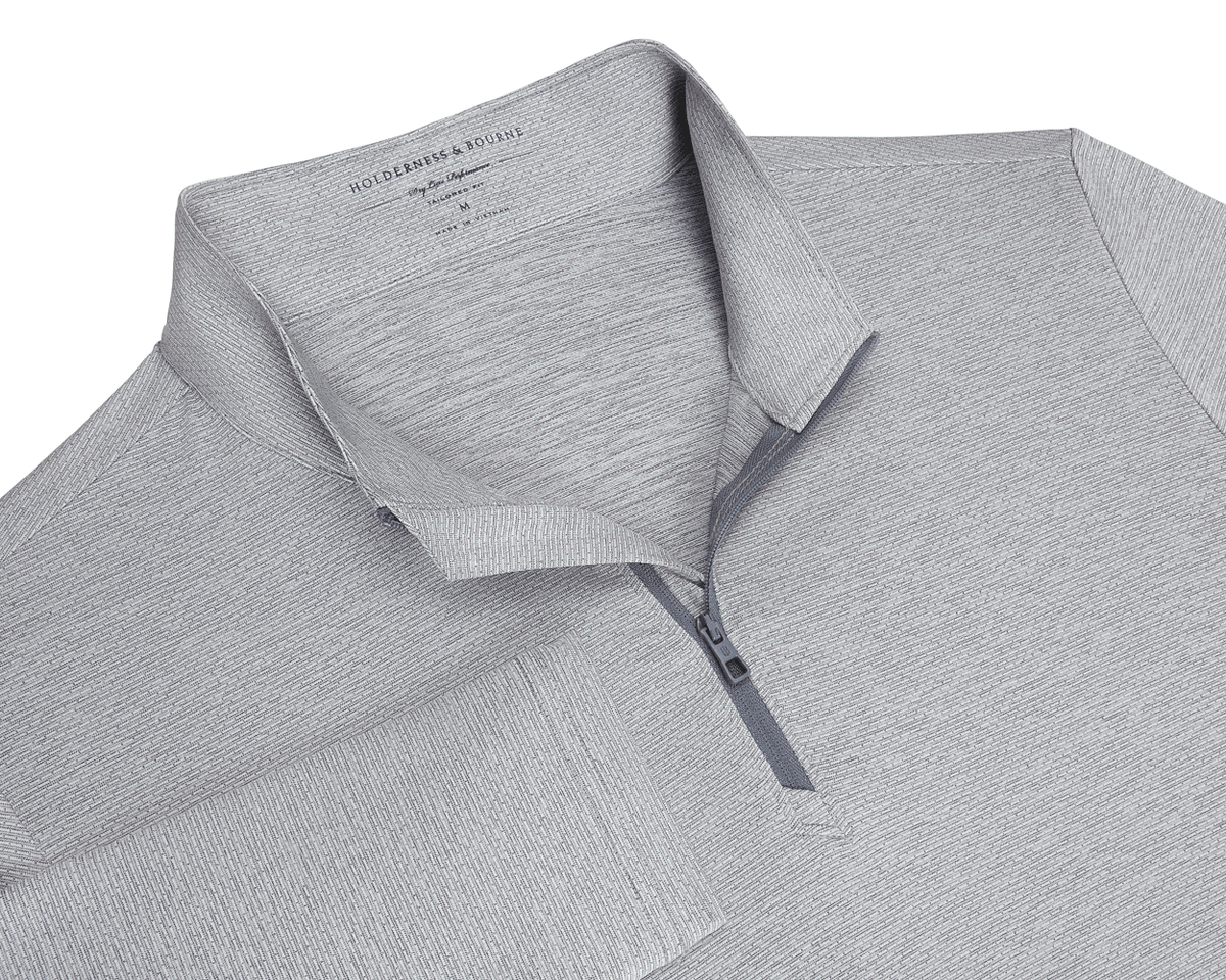 The Bell Quarter-Zip: Heathered Gray, featuring a textured knit, fold-over collar, quarter-zip placket, and long sleeves, offering sporty sophistication and versatility.