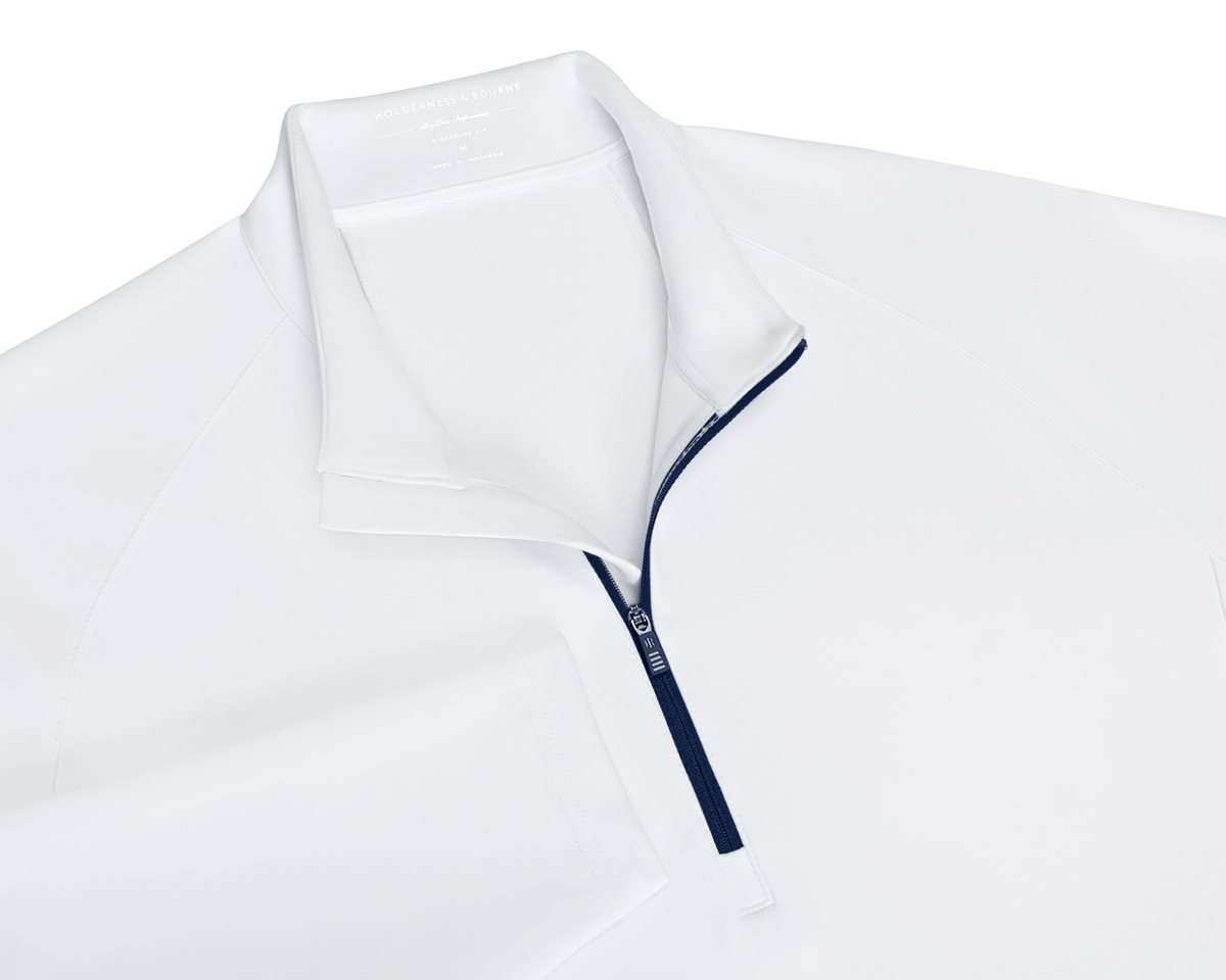 The Rodgers Quarter-Zip: White, featuring a navy-blue zipper, stand-up collar, and low-profile side pockets, ideal for golf with UPF 50+ protection.