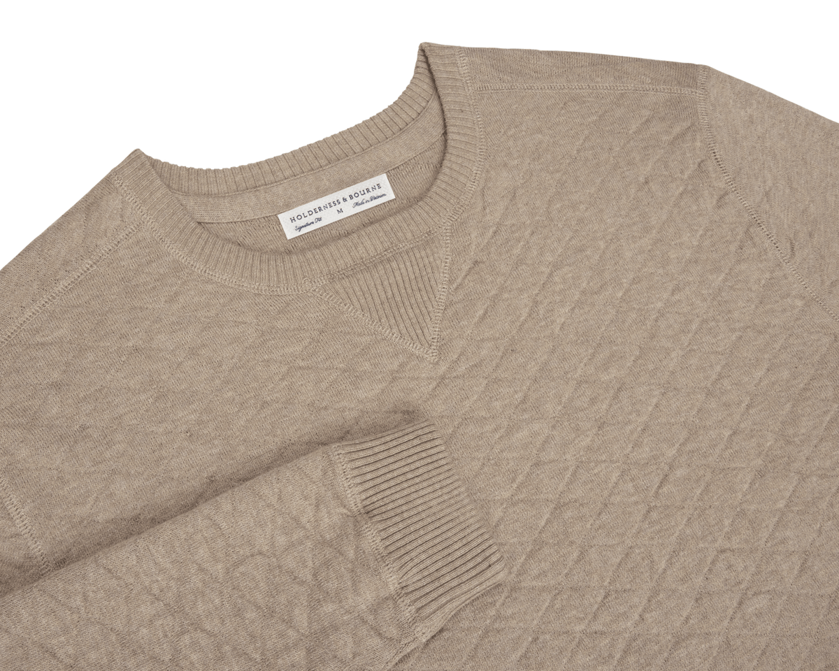 The Ward Crewneck Sweater: Heathered Light Dune, features a diamond-quilted pattern, ribbed cuffs, and premium Egyptian cotton, showcasing Holderness & Bourne's signature style.