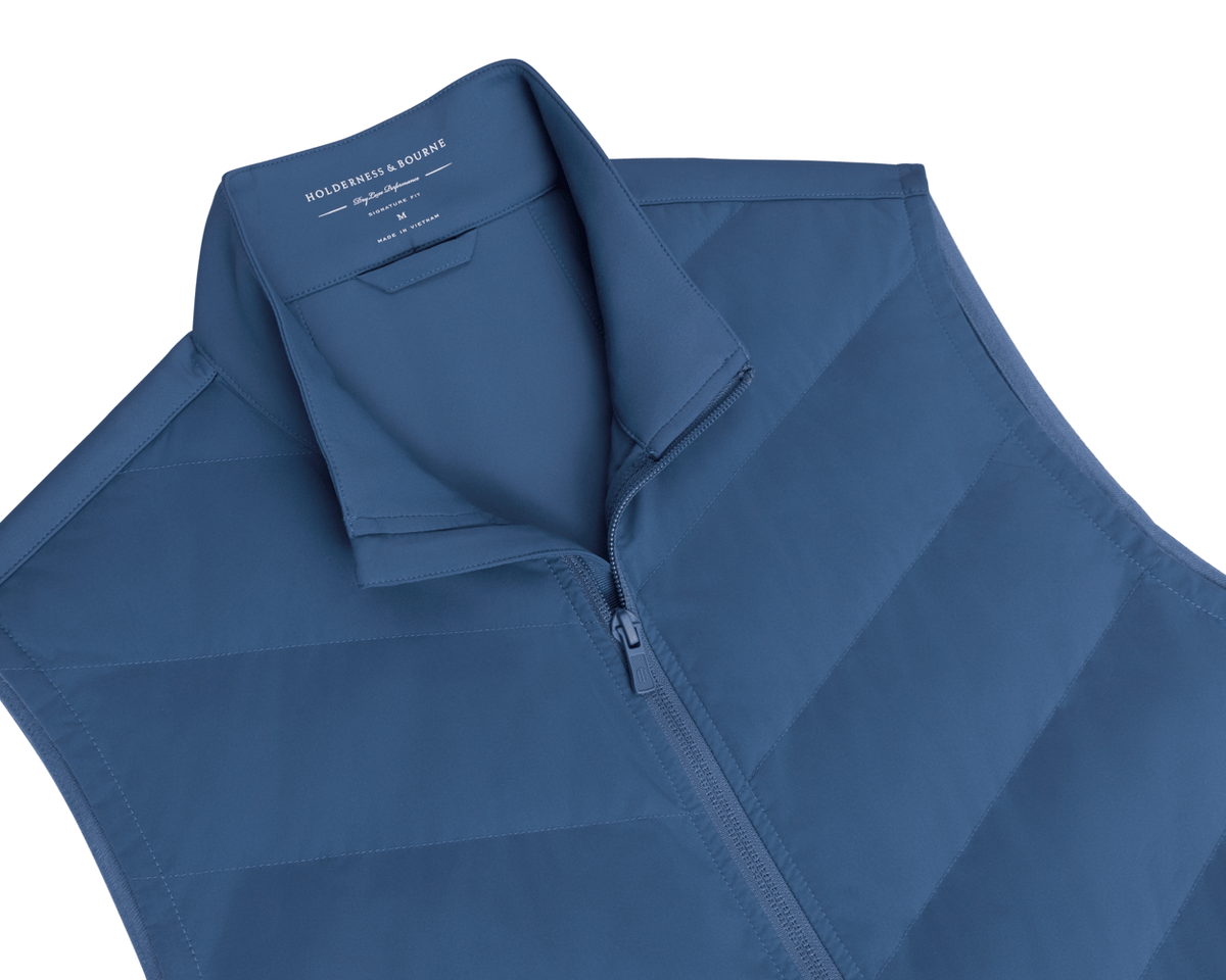 The Benton Vest: Andover, a men’s quilted sleeveless vest with a zip-front and stand-up collar, featuring Thermore® insulation and knit back for mobility.