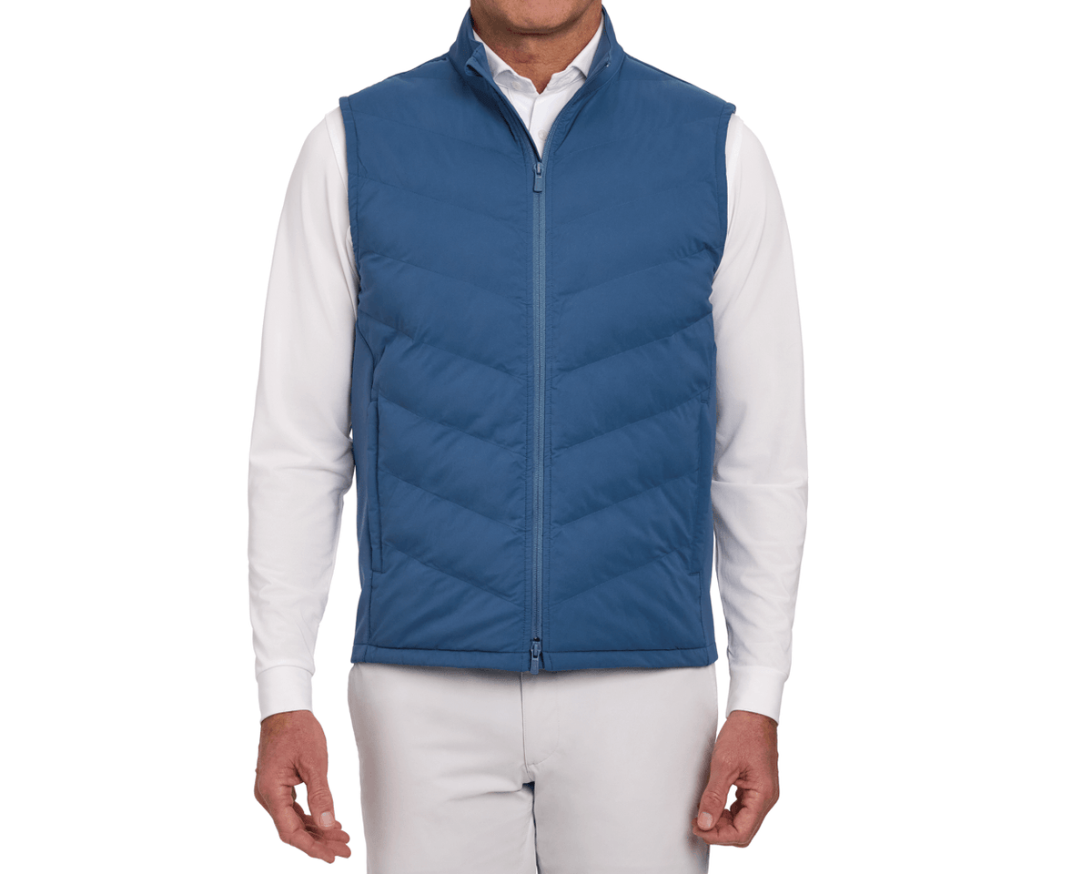 The Benton Vest: Andover, a quilted zip-front vest with Thermore® insulation and knit back, worn over a white shirt, emphasizing comfort and mobility.