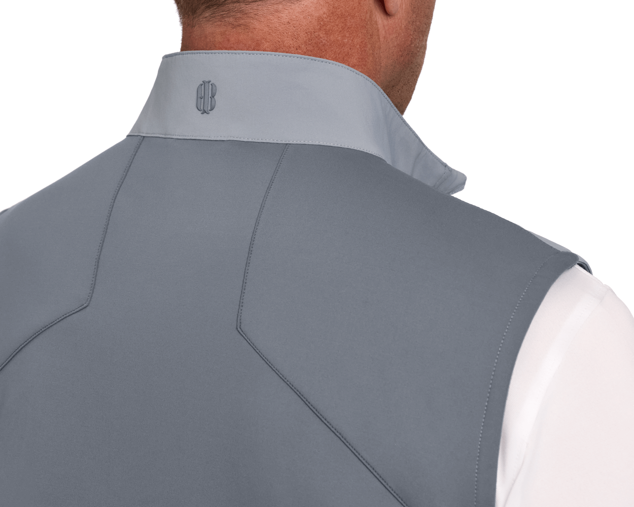 The Benton Vest: Gray, showcasing a soft-shell design with seam detailing and an embroidered logo on the collar, worn over a white shirt.