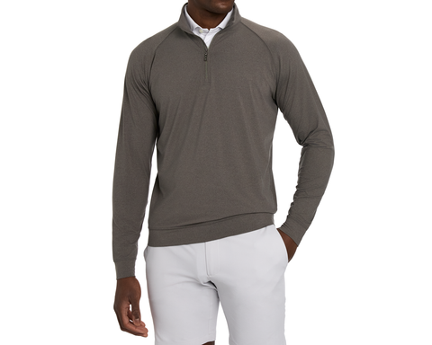 Model wearing The Westland Quarter-Zip: Heathered Driftwood with the zip partly open over a white collared shirt, one hand in the pocket of light gray shorts.