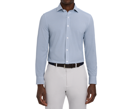 Model wearing The Goodrich Shirt: Pacific Blue, showing the button-front placket and spread collar, with a black belt and light gray pants.