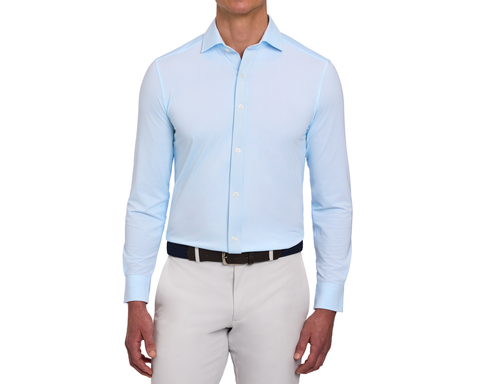 Model wearing The Goodrich Shirt: Vista Blue, showing the button-front placket and spread collar, with a dark belt and light gray pants.