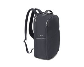 Angled side view of The Broughton Backpack: Dark Gray - White Embroidery, showing the padded shoulder straps, top zippers, leather trim, and white "CMB" monogram.
