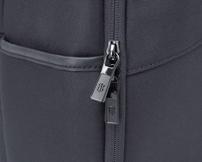 Close-up of The Broughton Backpack: Dark Gray showing the woven ballistic nylon, gunmetal zipper pulls, and leather-trimmed pocket edge.