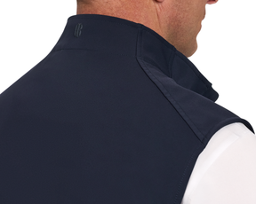 The Boyd Vest: Navy, shown from the back, features a turned-up collar with tonal logo, worn over a white shirt, highlighting its sleek, windproof design.
