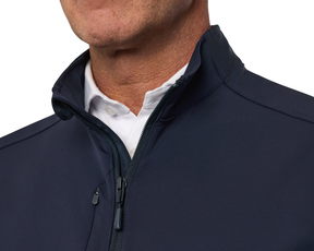 The Boyd Vest: Navy, worn over a white shirt, showcases its windproof, water-resistant design with a partially raised collar and two-way zipper.