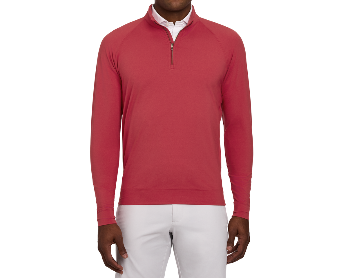 Model wearing The Westland Quarter-Zip in Liberty Red, featuring a quarter-zip design over a white shirt, paired with light-colored pants, showcasing its soft, moisture-wicking fabric.