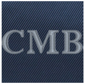 The Broughton Backpack: Navy Ballistic - Slate Blue Embroidery, showcasing C M B initials in pale grey on dark-blue denim-style fabric.