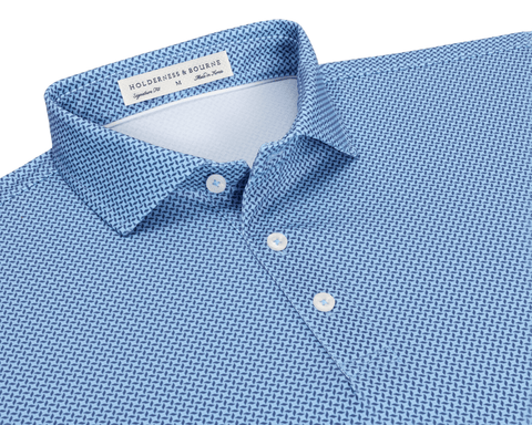 The Collins Shirt: Vista Blue & Pacific Blue flat-lay showing its spread collar, three-button placket, and interior label, with a geometric pattern on performance pique.