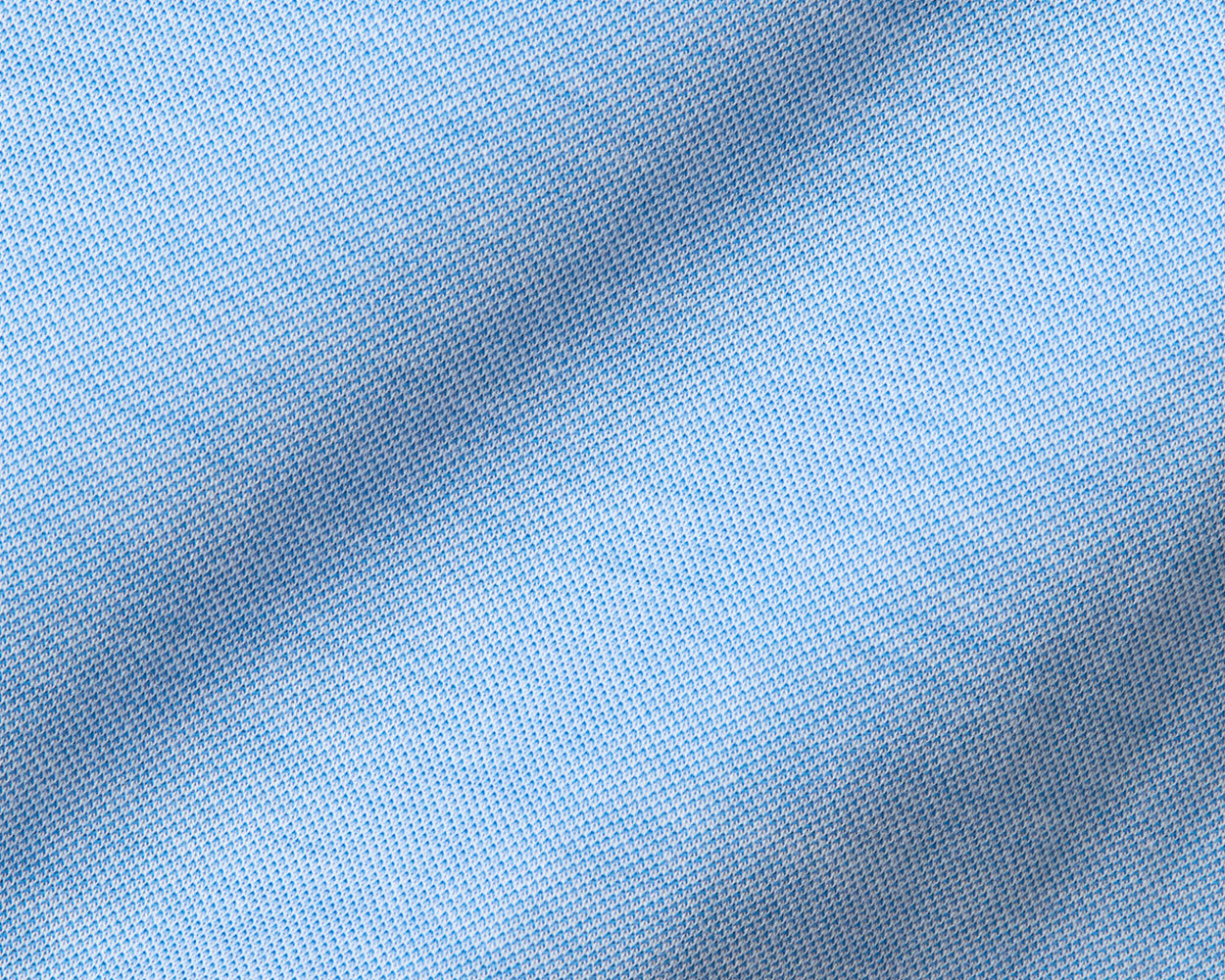 The Cullinane Shirt: Heathered Vista Blue features a light-blue knit fabric with a small mesh pattern, offering comfort, stretch, and UPF 30+ protection.