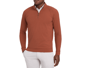 The Westland Quarter-Zip: Heathered Russet shown on a model, featuring a burnt-orange pullover over a white shirt with light trousers, highlighting its versatile style.