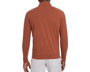 Back view of The Westland Quarter-Zip: Heathered Russet, showcasing its lightweight, moisture-wicking fabric, with gunmetal chrome trim and paired with light-colored pants.