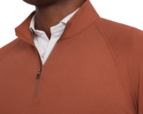 The Westland Quarter-Zip: Heathered Russet, a lightweight pullover with a stand-up collar and metal zipper, layered over a white shirt, showcasing raglan sleeves.