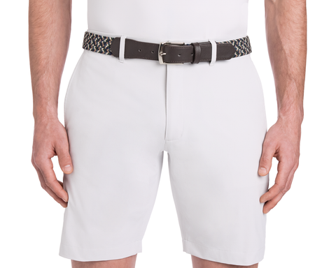 The Fischer Belt: Ivy Multicolor features a woven design with a dark leather buckle, shown on a model wearing white shorts, hands resting at sides.