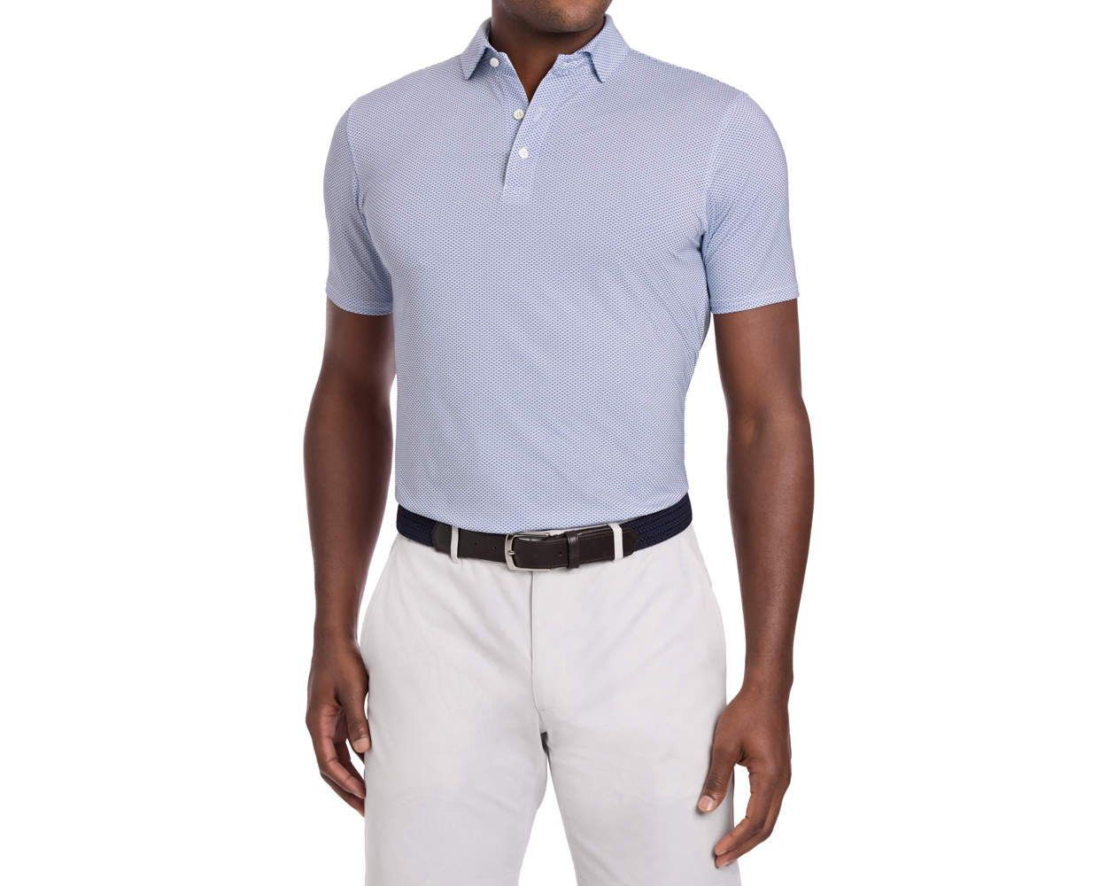 Man wearing The Armfield Shirt: Andover, a light-blue polo with subtle texture, tucked into light-beige trousers, featuring a dark woven belt.