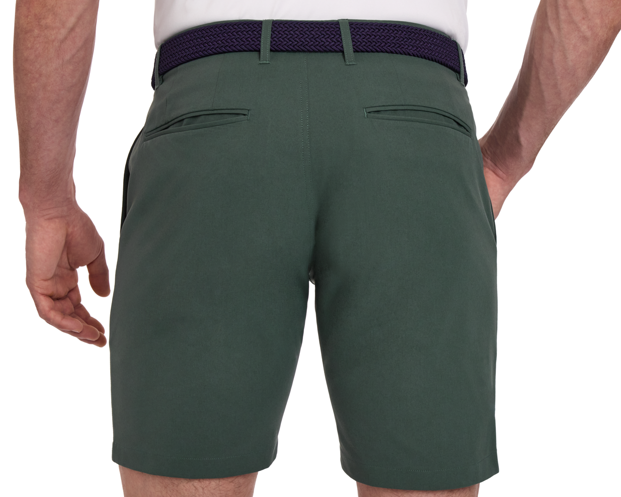 Man wearing The Harwood Short: Ivy, tailored forest-green shorts with welt pockets, braided belt, and a tucked-in shirt, showcasing comfort and style for golfers.
