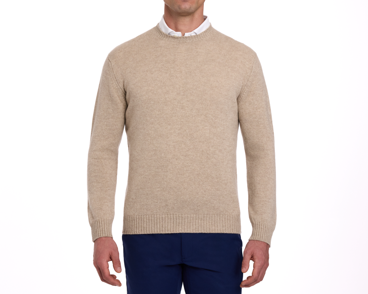 The Berwick Crewneck Sweater: Heathered Dune, made from plush Scottish cashmere, worn over a white shirt with navy trousers, showcasing classic and durable design.