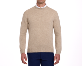 The Berwick Crewneck Sweater: Heathered Dune, made from plush Scottish cashmere, worn over a white shirt with navy trousers, showcasing classic and durable design.