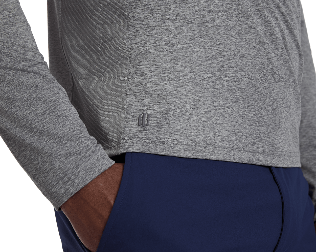 Close-up of The Dunbar Hoodie: Heathered Charcoal, showcasing light-grey heathered fabric with textured side panel and BB logo near hem, paired with navy workout pants.