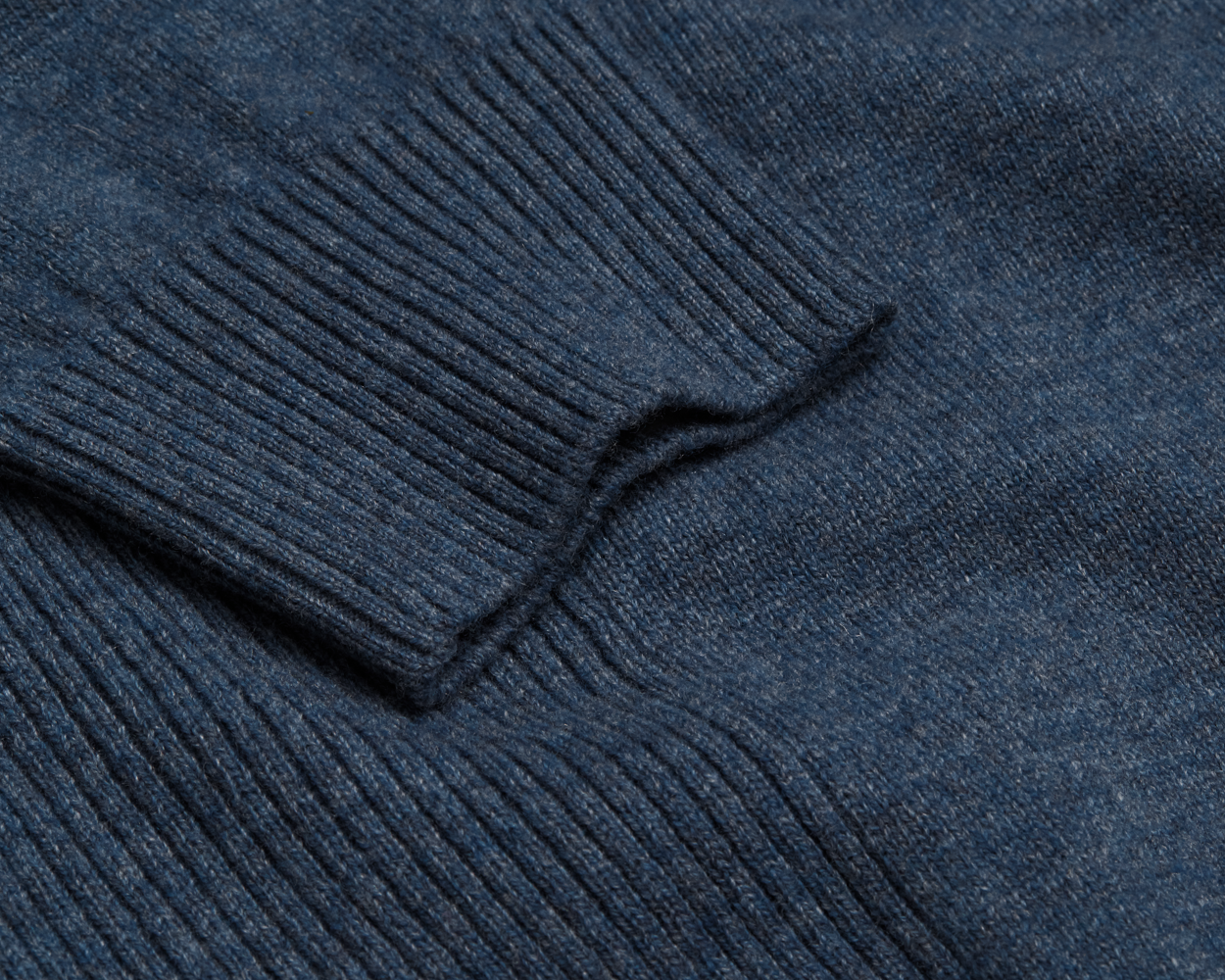 Close-up of The Logan Hoodie Sweater: Heathered Andover, showcasing rib-knit texture and folded cuff, highlighting its luxurious Merino wool-cashmere blend for warmth and breathability.