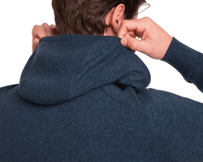 Person adjusting hood of The Logan Hoodie Sweater: Heathered Andover, showcasing ribbed texture on hood and cuffs, emphasizing luxurious Merino wool and cashmere blend.