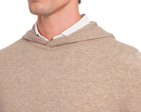 The Logan Hoodie Sweater: Heathered Dune, a soft-knit tan-beige hoodie over a white collared shirt, made from luxurious Merino wool and cashmere blend for warmth.