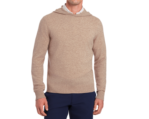 The Logan Hoodie Sweater: Heathered Dune on a model, showcasing its knit texture, ribbed trim, and minimalist hood design over a collared shirt with navy trousers.
