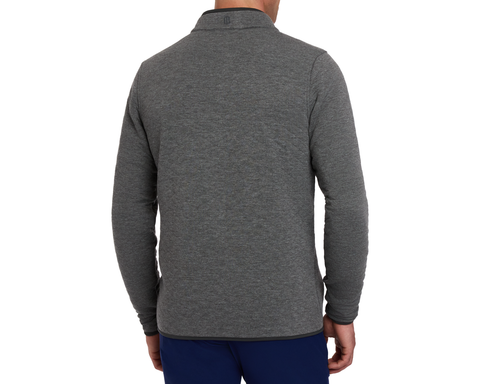 The Sullivan Quarter-Snap: Heathered Charcoal pullover with a stand-up collar and curved hem, worn with dark blue pants, showcasing its casual, versatile design.