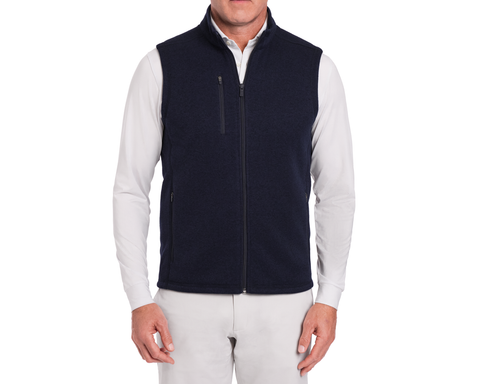 The Ashby Vest: Heathered Dark Navy, shown on a model over a white shirt, features zippered pockets and a soft brushed interior for versatile comfort.