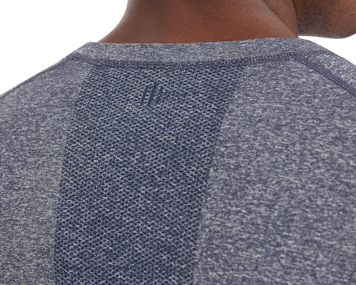 Close-up of The Carr T-Shirt: Heathered Navy, highlighting its textured fabric, raglan seams, central knit panel, and tonal logo below the collar.