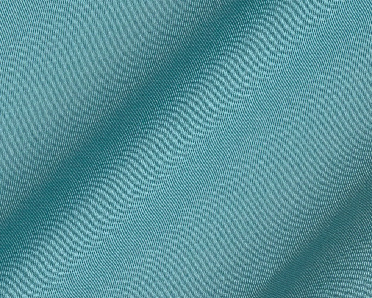 The Anderson Shirt: Harbor in teal features a close-up of fine diagonal ribbing with gentle fabric folds, highlighting its jersey knit for comfort and stretch.