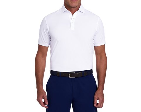 The Anderson Shirt: White polo with short sleeves, tucked into navy trousers, featuring a black braided belt. Offers stretch, moisture wicking, and soft jersey knit fabric.