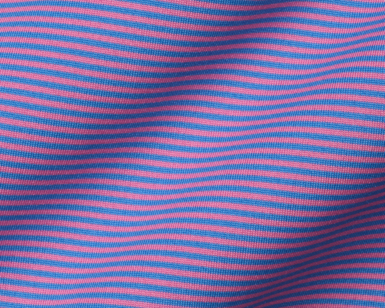 Close-up of The Perkins Boys Shirt: Horizon Blue & Belmont, showcasing its pink and blue striped knit fabric, hinting at its breathable, stretchy DryLuxe material.