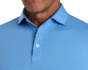 Close-up of The Perkins Shirt: Horizon Blue & Vista Blue, showcasing its light-blue, fine-striped fabric, classic button-up collar, and part of a man’s stubbled jawline.
