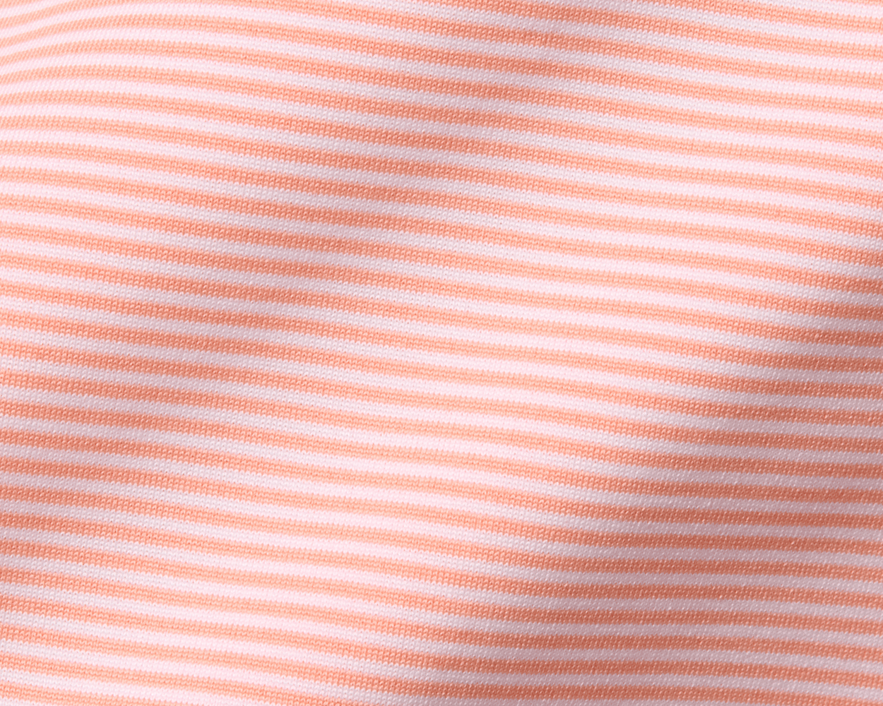 Close-up of The Perkins Shirt: Nectarine & White, featuring a soft knit fabric with fine horizontal stripes, showcasing its lightweight and moisture-wicking performance.