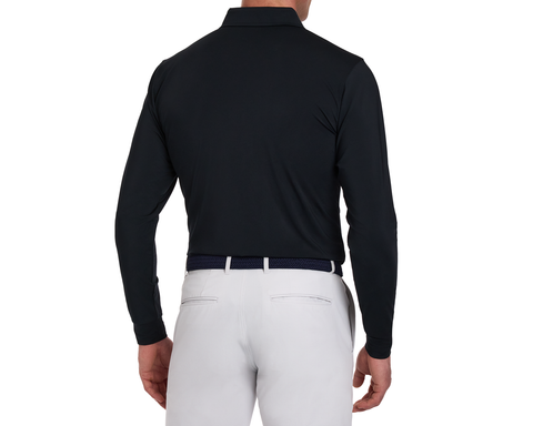 The Farrell Shirt: Black, long-sleeve polo with signature spread collar, tucked into light gray trousers, showcasing a sleek back view with a dark woven belt.