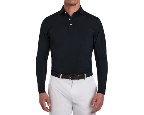 The Farrell Shirt: Black, long-sleeve polo with three-button placket, distinctive spread collar, worn with light trousers and a woven belt with leather accents.