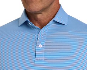 A person wears The Burke Shirt: Horizon Blue & White, featuring a light-blue polo with fine white stripes, collar, and button placket, offering UPF 50+ protection.
